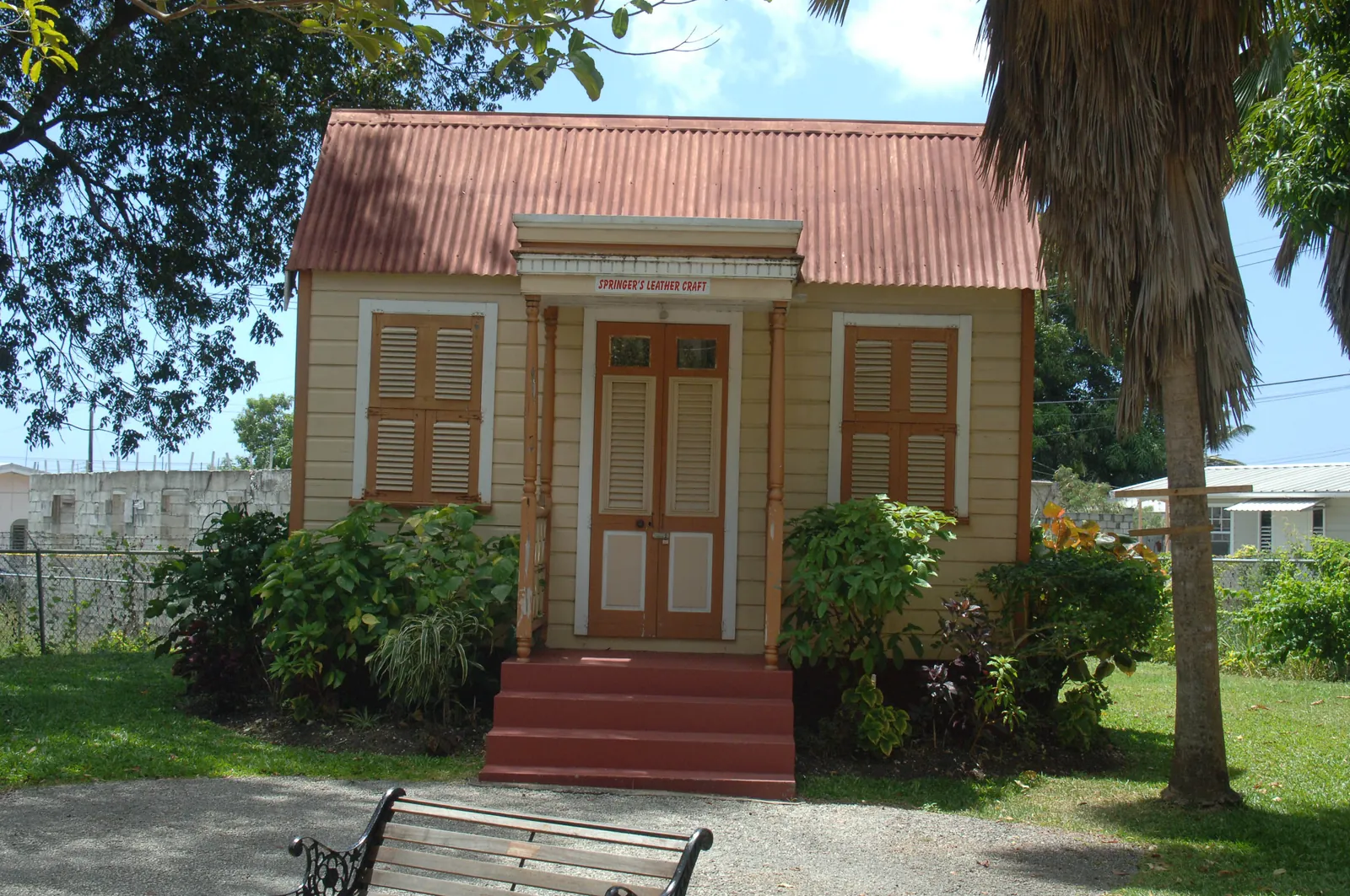 Small timber house with a steep gable roof and shuttered windows at Tyrol Cot Heritage Village, St Michael, Barbados