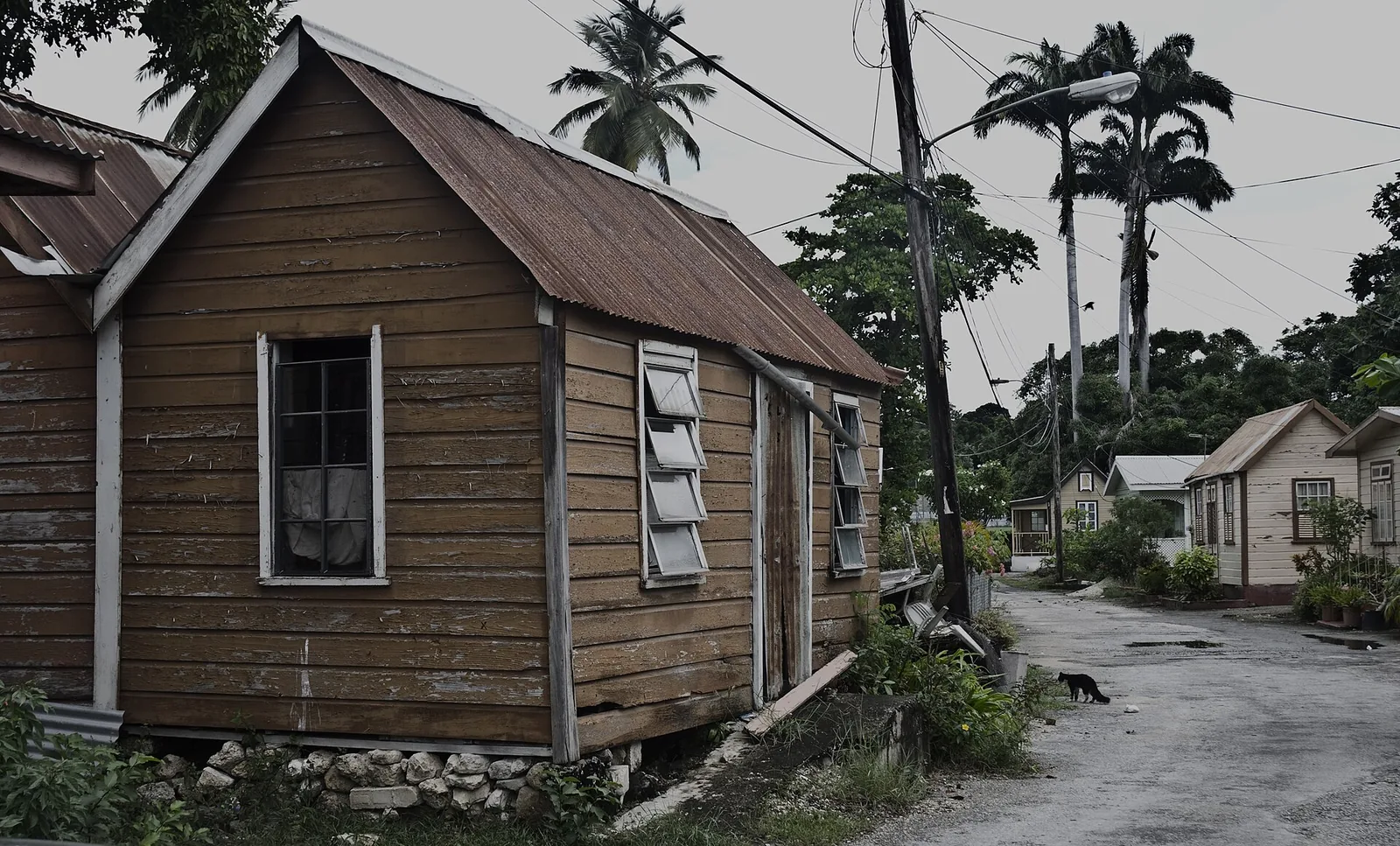 Timber chattel house raised on loose blocks beside a road in Barbados