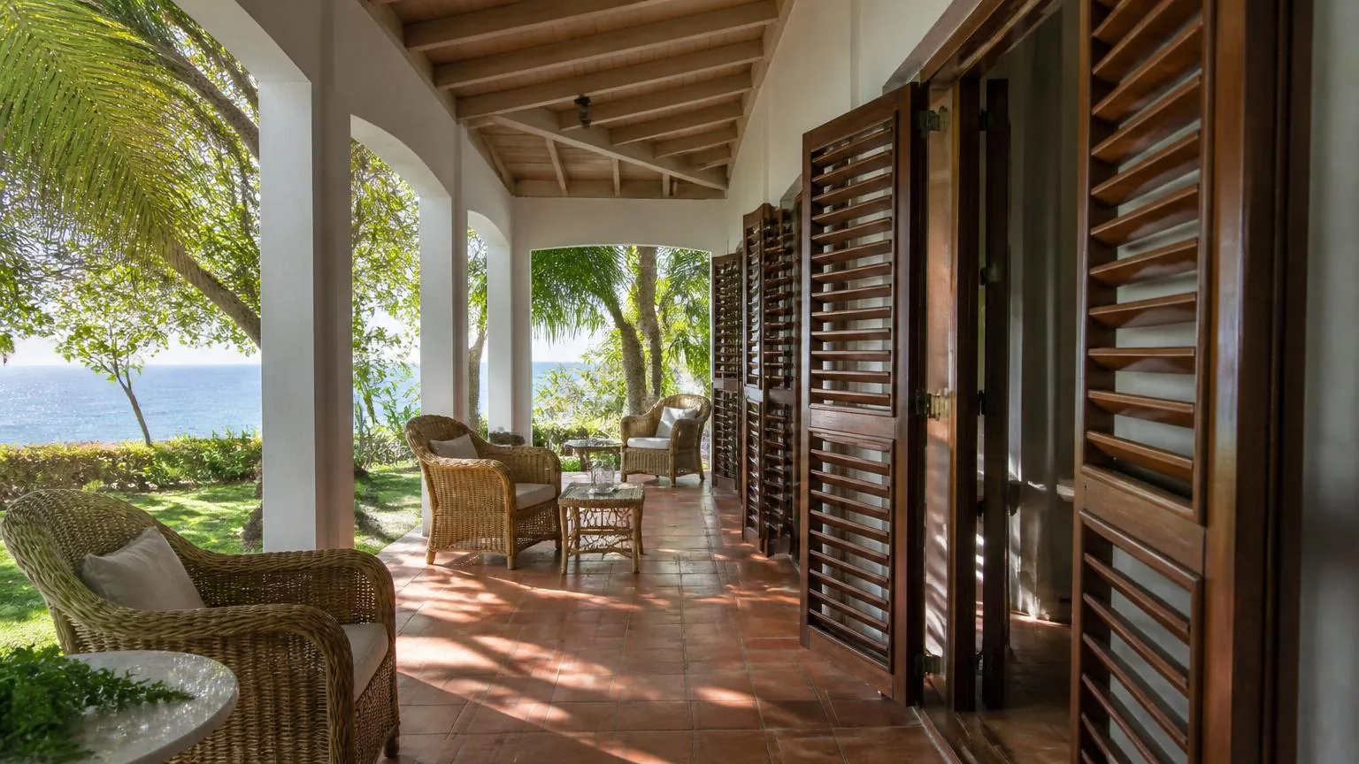 Deep shaded verandah with timber jalousie shutters catching the trade winds